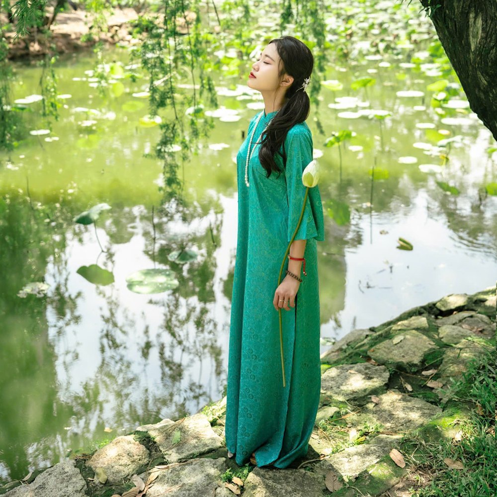 Áo dài cổ trụ xanh cổ vịt lụa gấm hoa văn cây leo