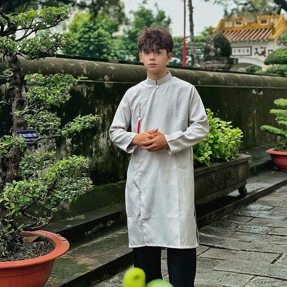 huê Áo Dài Nam Nút Sao tại Tiệm Nhà Bông – Vải gấm mềm cao cấp, form cách tân, 5 nút sao giữa, không họa tiết. Đủ màu: vàng kem, đỏ, nâu, trắng, đen, xanh. Size M–2XL.