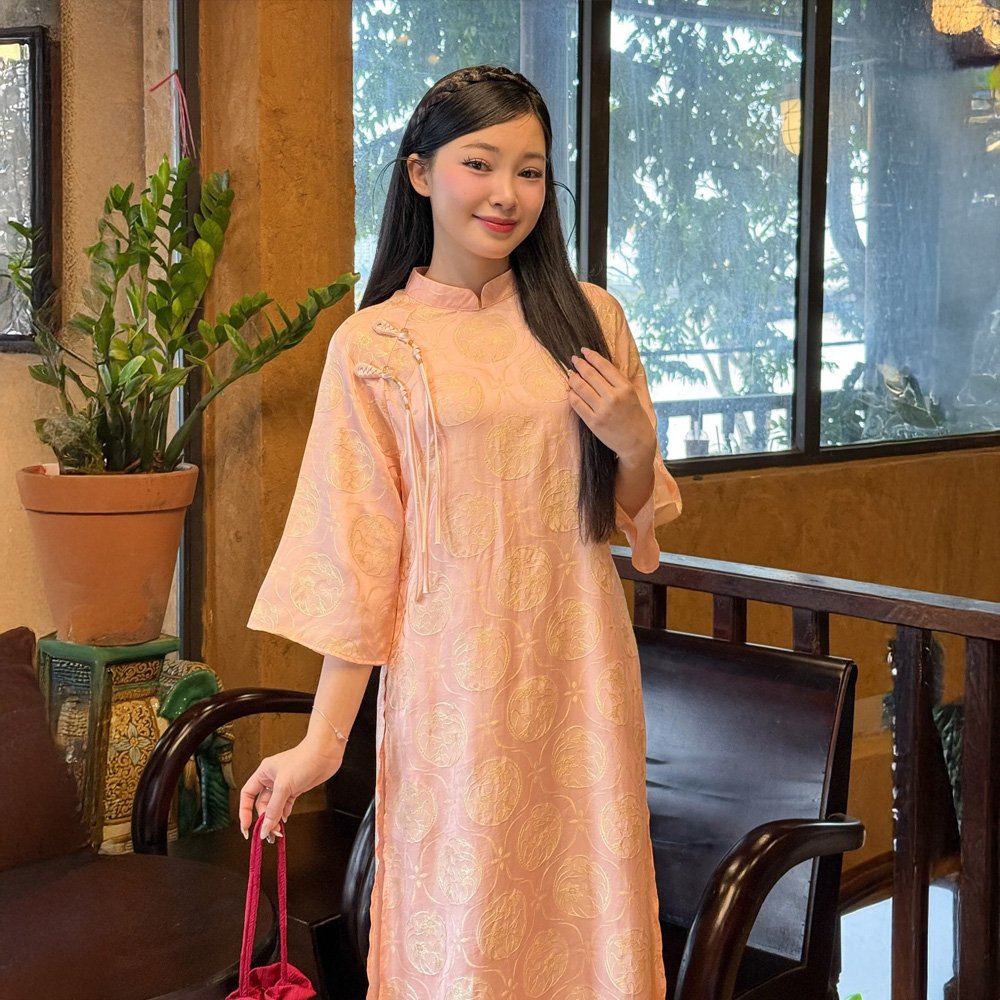 Áo Dài Cam Tuệ Dĩnh 2 Nút Tua Rua mang vẻ đẹp rạng rỡ với gam cam ấm áp, thiết kế 2 nút tinh tế và tua rua độc đáo. Phù hợp thuê chụp ảnh, dự tiệc, kỷ yếu, tiệc cưới; có sẵn bigsize.